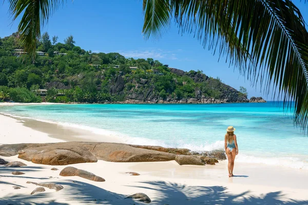 一个带有仿制空间的热带旅游概念横幅 展示了一个身穿泳衣的女人在带着棕榈树和碧绿大海的天堂海滩上行走的情景 — 图库照片