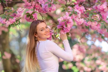 Büyüleyici bir sarışının romantik portresi çiçek açan bir bahçenin arka planında.