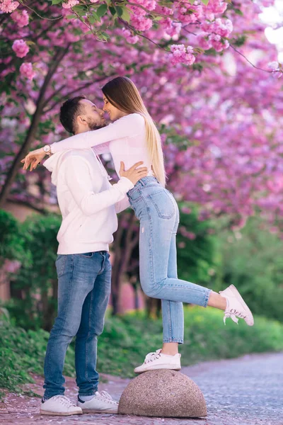 春の公園で桜が美しい春の日にデートをしているカップル — ストック写真