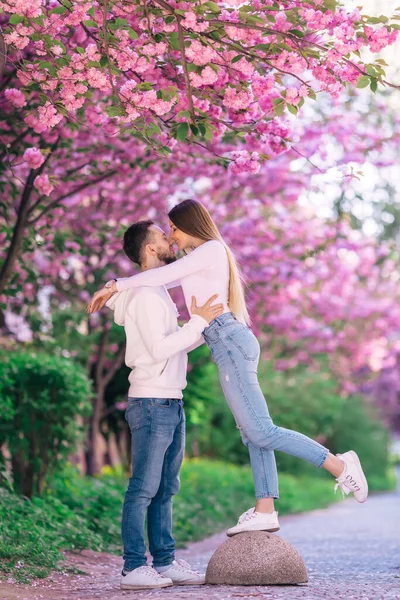 春の公園で男と女の子のためのロマンチックな休日 桜の庭で若いカップルに会う — ストック写真