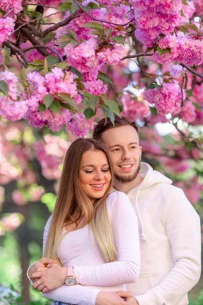 街の通りに桜の木の開花に近い感情的な幸せなカップル 春の家族の表情 — ストック写真