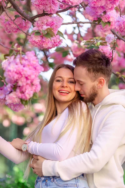 Bonito Jovem Lindo Abraço Casal Perto Uma Sakura Rosa Florescente — Fotografia de Stock
