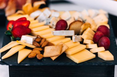 Tezgahta badem ve çilekle süslenmiş peynir dilimlerinin yakın çekimi. düğün.