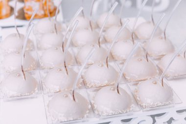 İnci ve hindistan cevizi taneleriyle süslenmiş jöleli beyaz tatlılar. Çikolata.