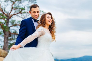 Sevgili çift düğün günü dışarıda poz veriyor.