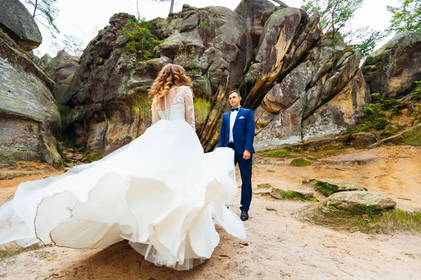 Gelin Kameraya Geri Çekiliyor Elbisesi Uçuyor Damat Kayaların Arkasında Ona — Stok fotoğraf