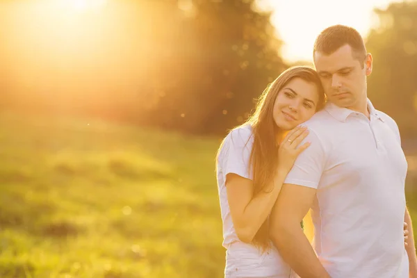幸せなカップルはオレンジの夕日の背景で笑って抱擁 幸福の概念 — ストック写真