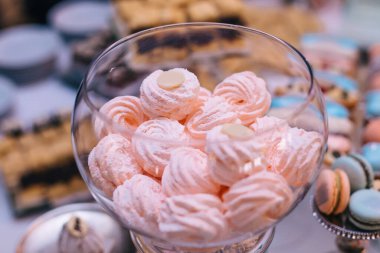 Şenlikli tatlı bir masada cam bir kavanozda güzel, yumuşak şekerlemeler.