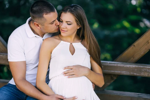 公園のベンチにいる愛のカップル夫と妊娠中の妻幸せな家族 — ストック写真