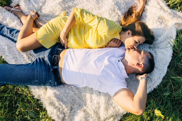 Pregnant Smiling Couple Lies Kisses Blanket Meadow — стоковое фото