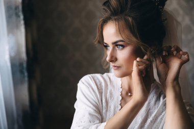 Gelin sabahı. Gelini yaklaşan düğüne hazırlıyorum. Kadın mücevher takıyor..