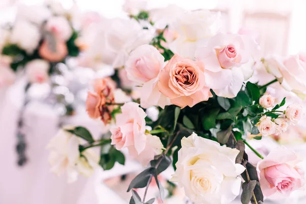 Wedding decoration table in the hall, floral arrangement. In the style vintage. Decorated dining table with flowers for guests and newlyweds, in peach-pink, pastel color.