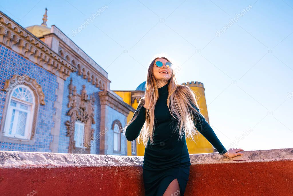 A tourist woman admires the popular Portuguese historical landmark Pena National Palace.