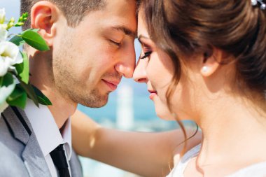 Yakın çekim yeni evliler gözlerini kapattı ve başlarını eğdi