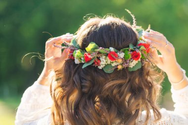 Close-up of girl's head from back side. curly hair and wreath on the head