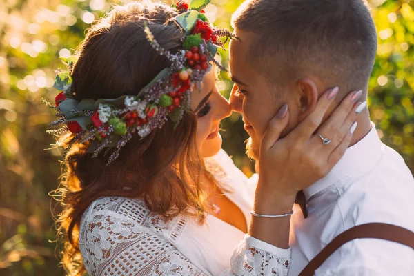 Close-up of a couple with closed eyes smiles and standing face to face. girl with a wreath on the head.