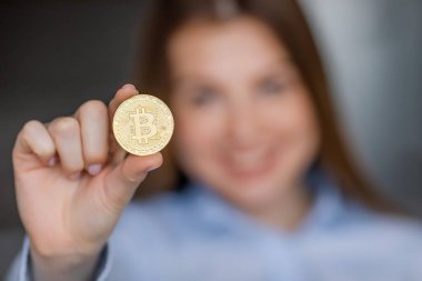 Woman showing Bitcoin gold coin. cryptocurrency