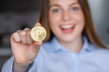 Genç iş kadını altın sikkesini içeride gösteriyor.