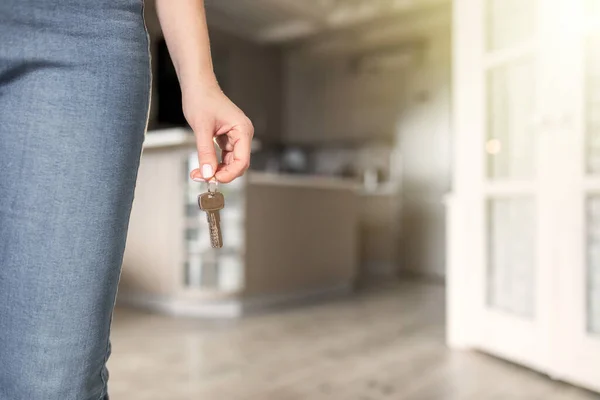 House key in woman hands, concept of moving or rent apartment