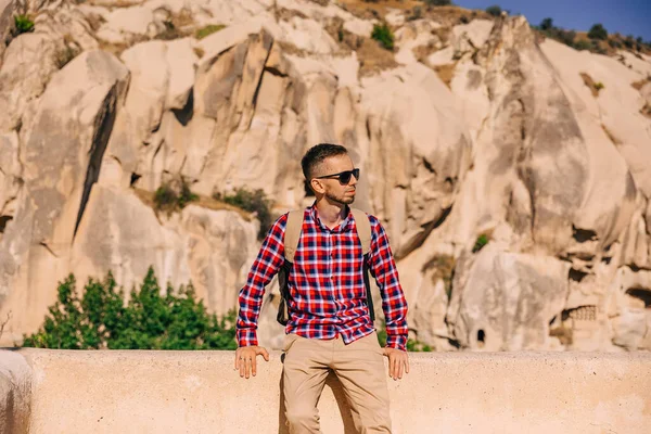 Man Bright Shirt Glasses Standing Stone Looks Beautiful Landscape — Φωτογραφία Αρχείου
