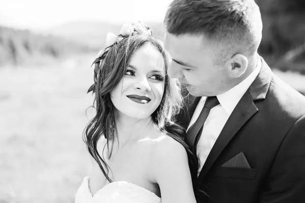 classic wedding picture, Married Couple embracing outside, black and white.