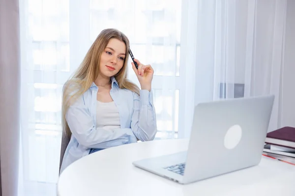 Woman Sits Table Computer Works She Holds Pen Looking Ideas — Zdjęcie stockowe