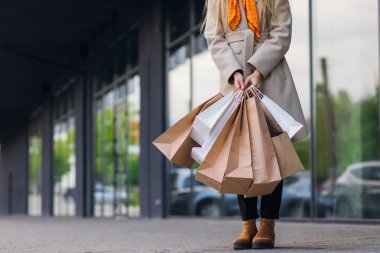 Street look, outfit. Woman with shopping packages.
