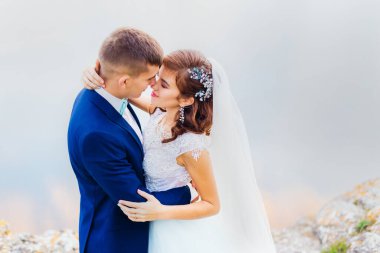 newlyweds lean their heads and closed their eyes on the river bank. close up