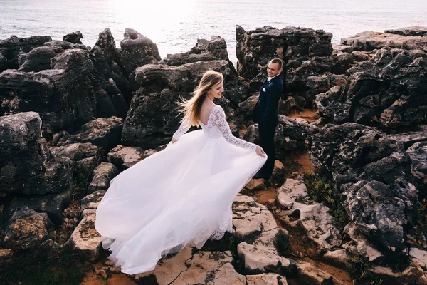 Newlyweds Large Rocks Overlooking Ocean Bride Back Camera Groom Smiles — Fotografia de Stock