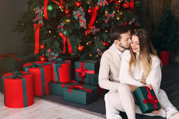 크리스마스 근처에 스웨터를 선물을 남자가 여자한테 키스하고 가까이 — 스톡 사진