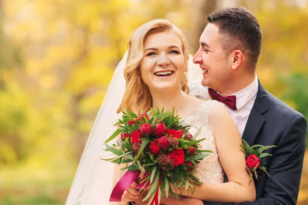 Krásná Nevěsta Drží Svatební Kytici Červených Pivoňek Ženich Objímá Nevěstu — Stock fotografie