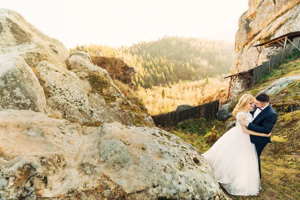 Noivo Abraça Noiva Eles Sorriem Fundo Falésias Montanhas Céu Natureza — Fotografia de Stock