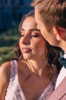 Güzel makyajlı bir gelin, damadına doğada sarılıyor..