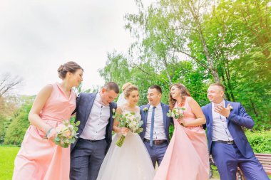 Yeni evlilerin, nedimelerin ve sağdıçların komik düğün anları. Parkta yürü.