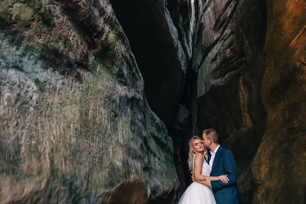 美丽的新娘和新郎在山岩上亲吻的侧面肖像 — 图库照片
