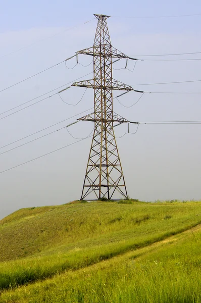 Torre de linha de energia no topo da colina verde — Fotografia de Stock