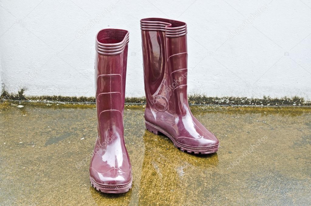 Rubber boots standing amongst rain puddles