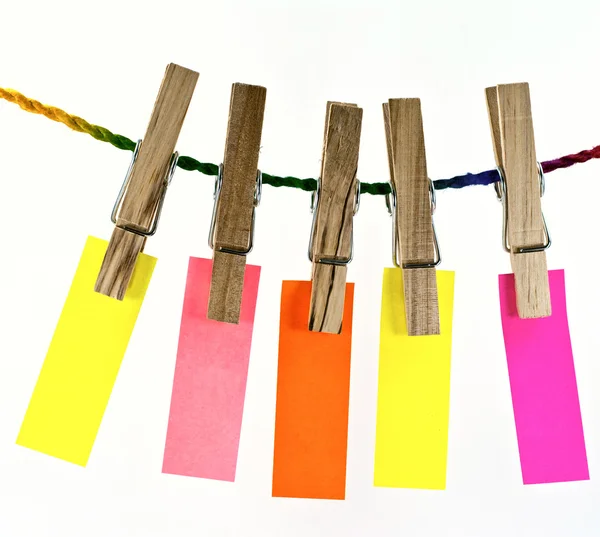 Spilla in legno e carta bianca colorata sulla corda — Foto Stock