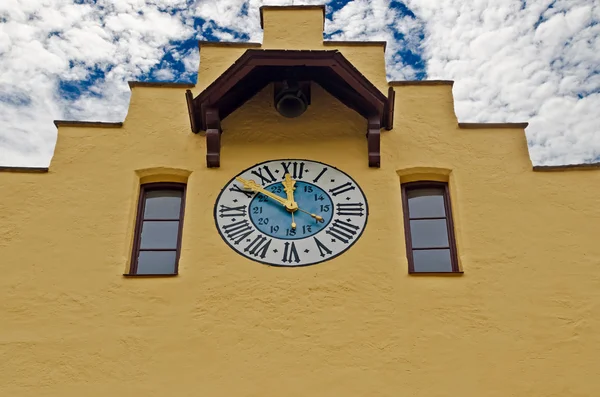 Römische Ziffernuhr an Hauswand mit blauem Himmel — Stockfoto