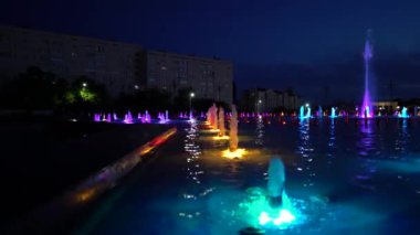 Gece çeşmesindeki çok renkli su fıskiyeleri sırayla yükselir.