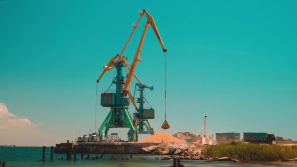 La grue portuaire répand du sable sur un gros tas de sable — Video