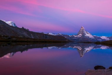 Beautiful sunset colors and cloudscape in the Swiss Alps in summer, with Matterhorn reflection in a lake