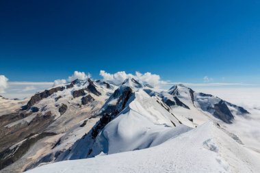 Kışın İsviçre Alpleri 'nin güzel dağlık manzarası dramatik bulutlu.
