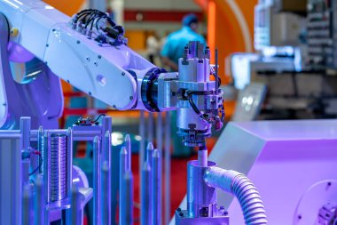automation system robot arm with gripper during bring process metal ring or workpiece to deburring process