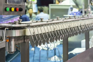 Close up automatic hanging conveyor belt line machine holder for sausages transport in manufacturing process food industrial