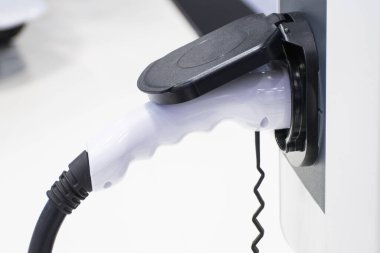 Aracın aküsünü şarj etmek yeni otomotiv yenilikleri şarj edilen elektrikli bir arabaya takılan güç kaynağı, enerji yeniliği kavramı..