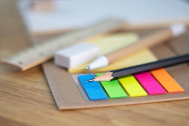Yazmak için seçici odak kalem ve çok renkli kare renkli yapışkan notlar, cetveller ve ahşap masa konsept ekipman ofisi ve okul hakkında kağıt kitap