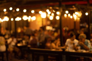 Restorandaki bulanık görüntü, restorandaki birçok insan yemek yiyor ve eğleniyor. 