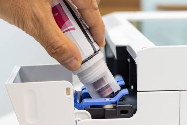 Teknisyenler mürekkebi yerleştirip dolgu deliğine mürekkep sokuyorlar. bir mürekkep püskürtme yazıcısının, yazıcı için ofis otomatik aygıtı