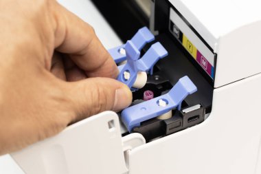 Teknisyenler doldurma deliğini bir mürekkep püskürtme yazıcısının mührü ile kapatıyorlar. Yazdırma için ofis otomatiği.